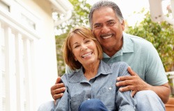 older couple hugging and smiling outside 