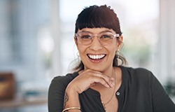 a smiling woman wearing glasses