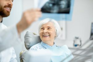 Dentist reviewing dental scan with smiling patient