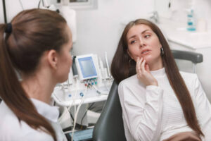 Woman with mouth pain in dentist’s chair