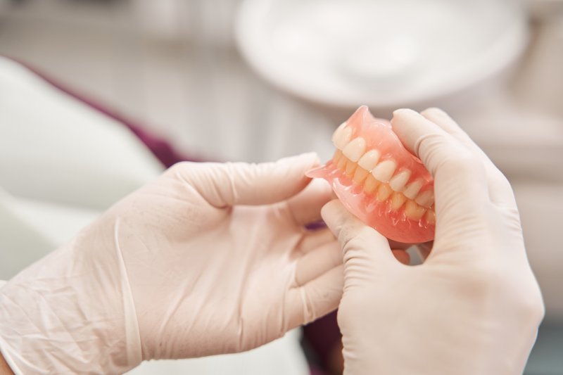 dentist holding a pair of dentures